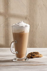 Latte cup and cookies on the wooden table.