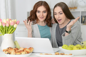 two young women using laptop