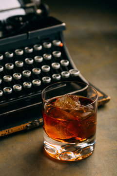 Glass of whiskey and a retro typewriter