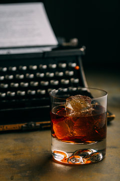 Glass of whiskey and a retro typewriter