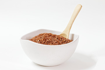 Thai Black or dark brown raw rice in a white bowl for a healthy diet. High fiber, vitamin, carbohydrate, minerals, and nutrition for healthy people. on the white background, isolate.