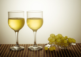 Wineglasses with white wine and grapes