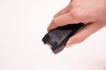 The girl's hand holds an Electroshocker. Self-defense. White background.