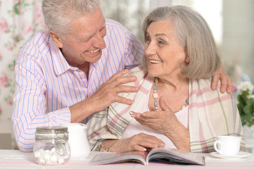 Senior couple drinking tea  and reading magazine