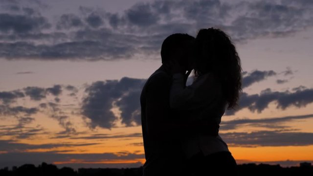 Romantic Couple Silhouette. Man With Woman Together Are Lovers Kiss At Sunset
