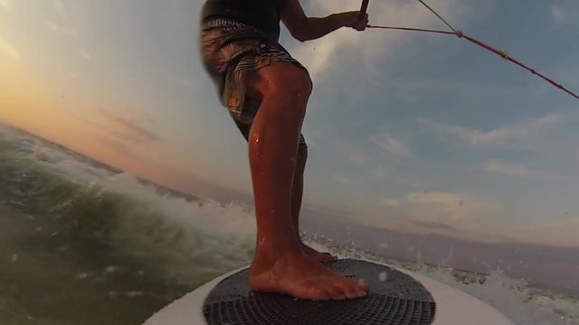 Man on a wakeboard performs a 180 degree turn