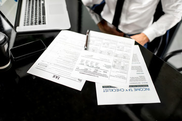 Manager working with tax documents. Image focused on the documents