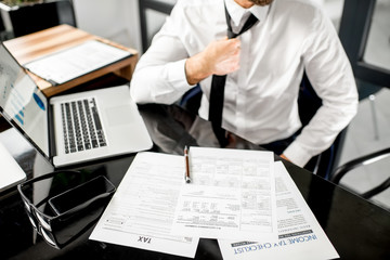 Manager working with tax documents. Image focused on the documents