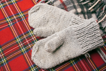 Baby woolen mittens on a red background