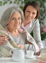  Senior woman with daughter drinking tea