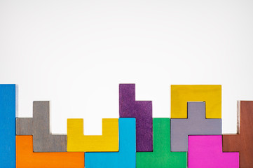 Different colorful shapes wooden blocks on beige background, flat lay. Geometric shapes in...