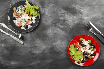 Greek salad feta, cherry tomatoes, olives, cucumbers on a dark background. Top view, copy space. Food background