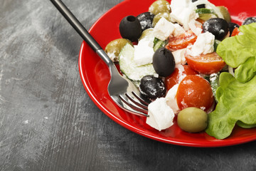 Greek salad feta, cherry tomatoes, olives, cucumbers on a dark background. Copy space. Food background