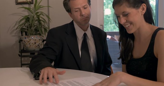 Shady deceitful deceptive businessman giving paperwork to a woman to sign