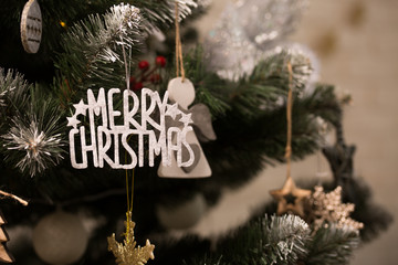 Merry Christmas sign on green snowy christmas tree with bokeh