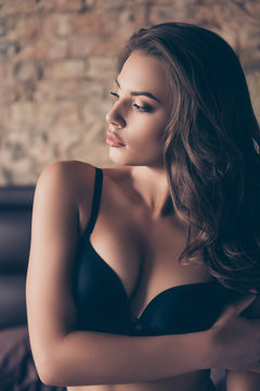 Close up cropped shot of adorable glamourous fancy coquette in sexy dark silk underwear, posing with crossed hands, tempting, pretty, with curly nice hair, smooth skin, light cute cosmetics