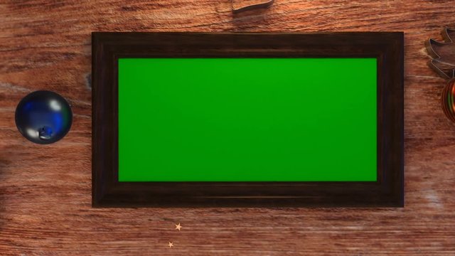 Top view of green screen photo frame on wooden table with christmas decoration