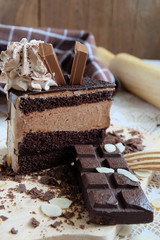 A piece of chocolate cake with chocolate bar on the table
