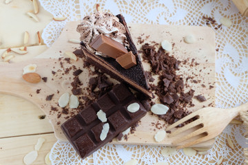 A piece of chocolate cake with chocolate bar on the table