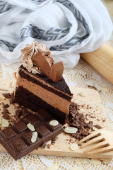 A piece of chocolate cake with chocolate bar on the table