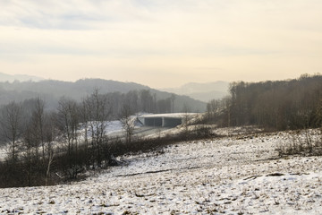 foggy winter day over road through hills