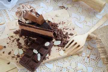 A piece of chocolate cake with chocolate bar on the table