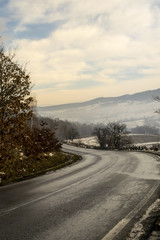 foggy winter day over road through hills