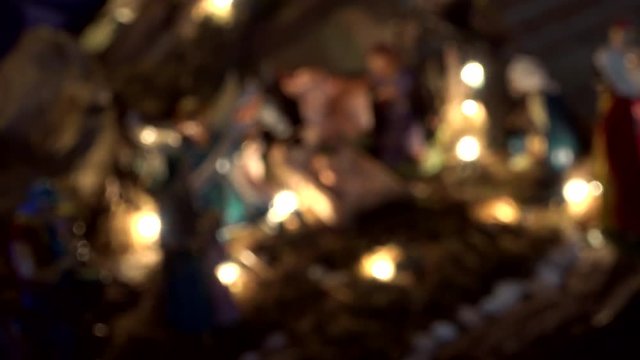 from blur to focus shot of Nativity scene with The Holy Child, The Blessed Virgin Mary, Saint Joseph, The Three Wise Men and ox and donkey