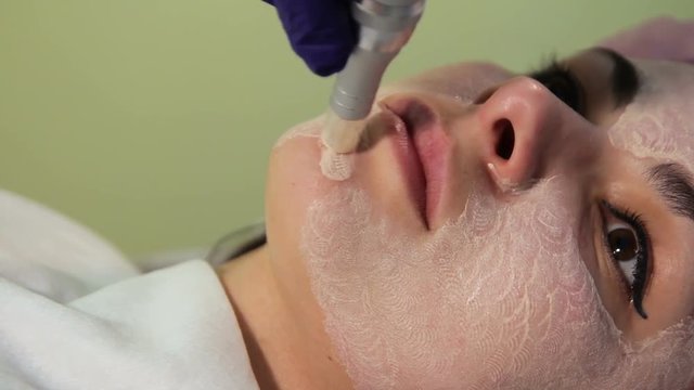 The young woman's face during the procedure closeup. Innovative cosmetic procedure. Medical procedure rejuvenation. Electrical dermapen