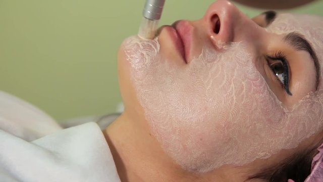 The young woman's face during the procedure closeup. Innovative cosmetic procedure. Medical procedure rejuvenation. Electrical dermapen