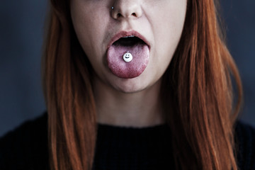 Girl with pill on tongue