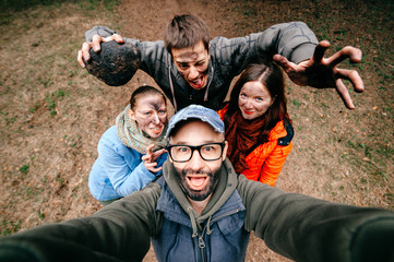 Four crazy funny people selfie. Bizarre scary company mess outdoor. Disgusting creepy fellows fooling around. Unusual dirty face emotions. Wide angle distortions. Evil family. Expressive pesrons party