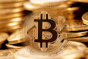 Gold bitcoin on the background of pile of coins