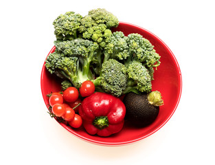 Broccoli, cherry tomatoes, black radish and peppers on plate.