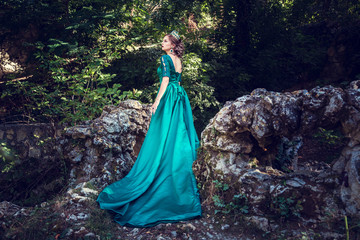 Naklejka premium Young woman wearing a green dress explores a magical forest