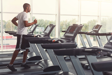 Young man in gym run on treadmill