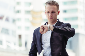 Smart businessguy looking watch in rush hour time
