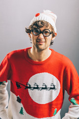 Grumpy man in funny christmas clothes and glasses.
