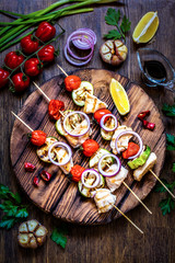 grilled chicken with zucchini, tomatoes, onions and herbs on a wooden Board