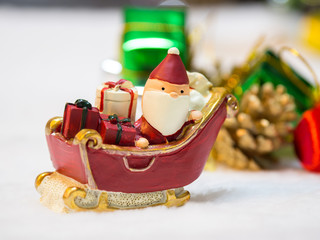 Happy Santa Claus with gifts box on the snow sled the background is Christmas decor.Santa Claus and Christmas decor on the snow. Merry Christmas and happy new year concept