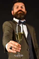 Man with beard holds glass of champagne