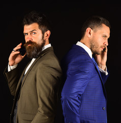 Business call concept. Businessmen with serious faces hold mobile phones