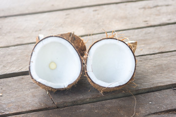 Ripe half cut coconut on a wooden background.
