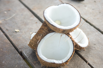 Ripe half cut coconut on a wooden background.