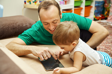 little boy with father looking to tablet computer