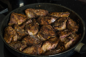 The cook prepares the fried liver in a frying pan on an induction cooker