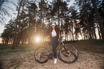 Fototapeta na wymiar Biker girl at the sunset in forest.