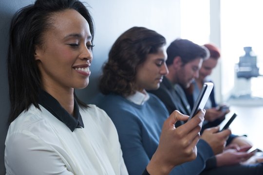 Team of business people using mobile phone