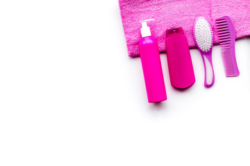 Basic hair care in bathroom. Comb, shampoo, spray, towel on white background top view copyspace