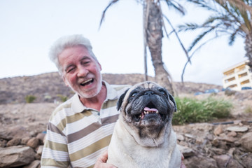 man plays with his pug puppy dog